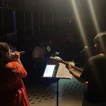 Lead singer passionately singing into microphone on stage, colorful lights in background, lively and dynamic mood