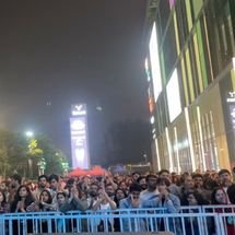 Band members performing on stage under dramatic lighting with purple and blue spotlights, energetic concert atmosphere, audience not visible