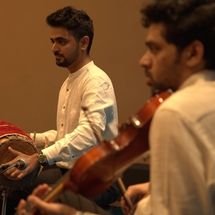 Close-up of keyboardist playing on stage, hands on keys, focused and joyful expression, colorful lights and stage equipment in background